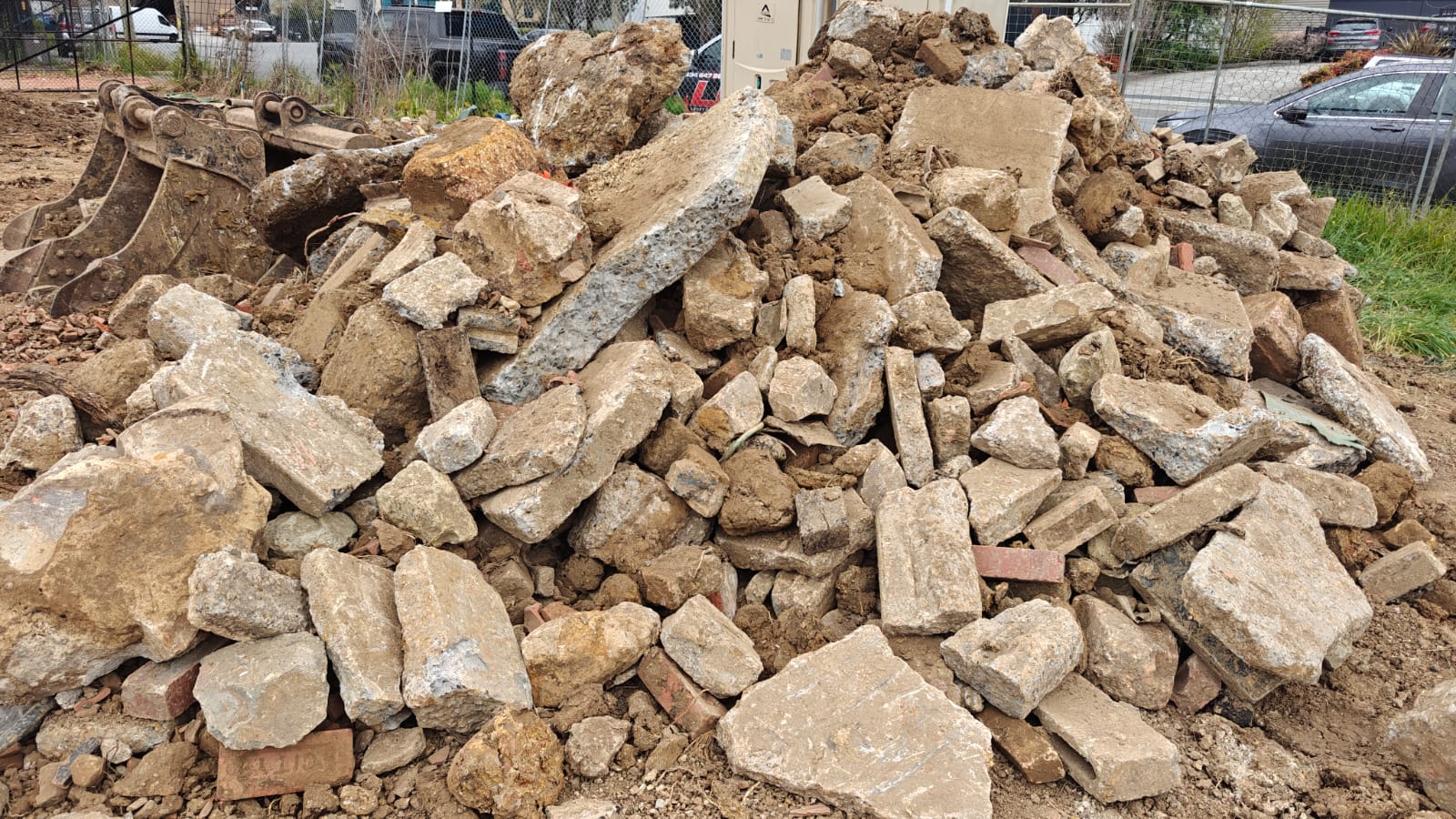 Large buried concrete fragments exposed within mixed fill during development-site excavation